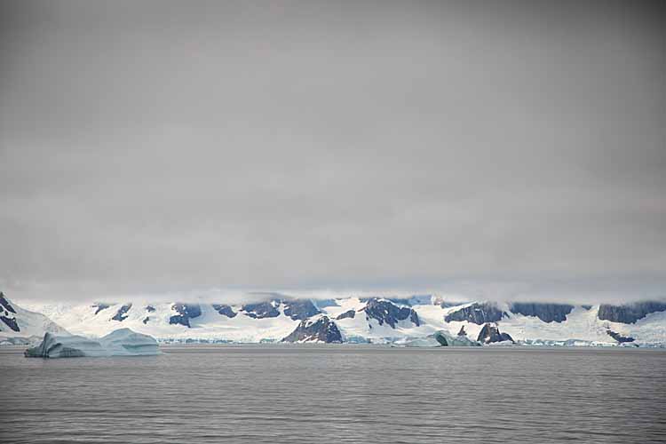 Shoreline and mountains with low cloud in Antarctica.