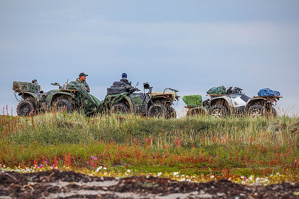 Quads or ATV's parked on the edge between the arctic tundra and ocean foreshore.