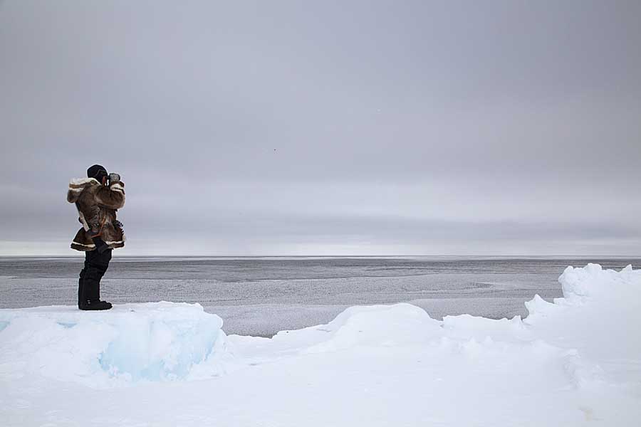 Inuit guide looking for wildlife on floe edge.