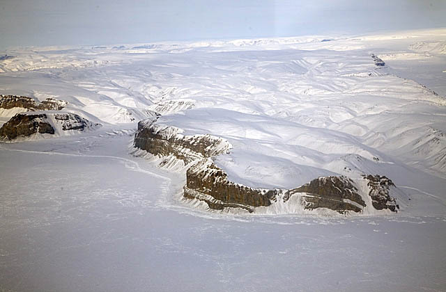 Snow covered seaside cliffs and sea ice.