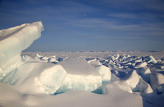 Lifted slabs of sea ice in pressure zone above ocean.